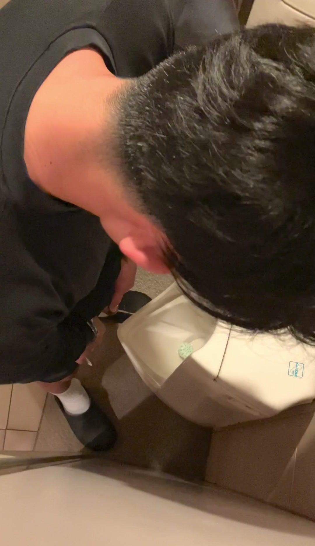 A male is pissing in the toilet. 8