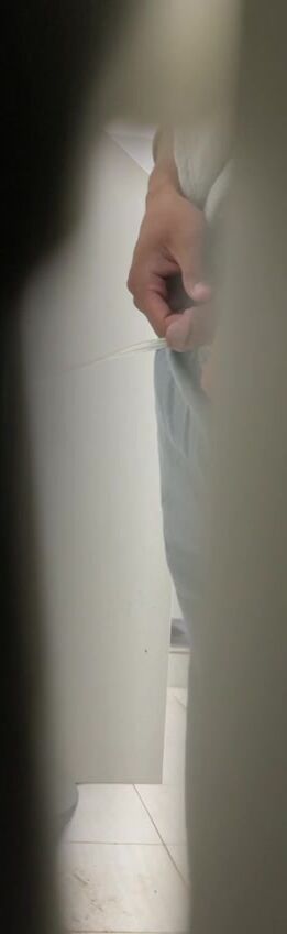 A male is pissing in the toilet. 10
