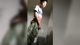 A male is pissing in the toilet. 13