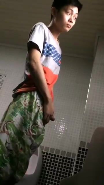 A male is pissing in the toilet. 13