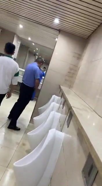 A male student is pissing in the toilet. 5