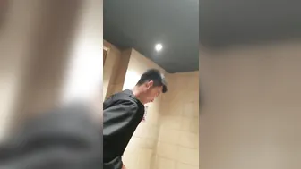 A male is pissing in the toilet. 15