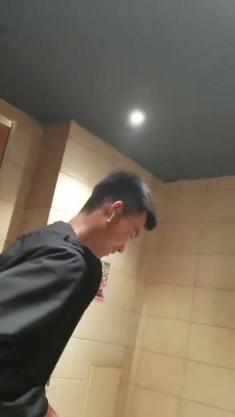 A male is pissing in the toilet. 15