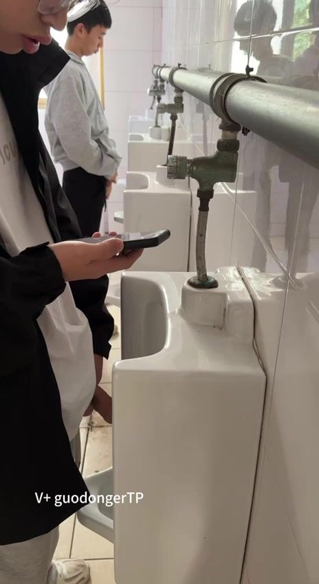 A male student is pissing in the toilet. 6