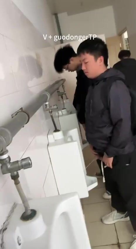 A male student is pissing in the toilet. 7