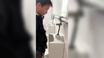 A male student is pissing in the toilet. 10
