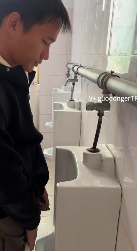 A male student is pissing in the toilet. 10