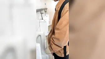 A male is pissing in the toilet. 23