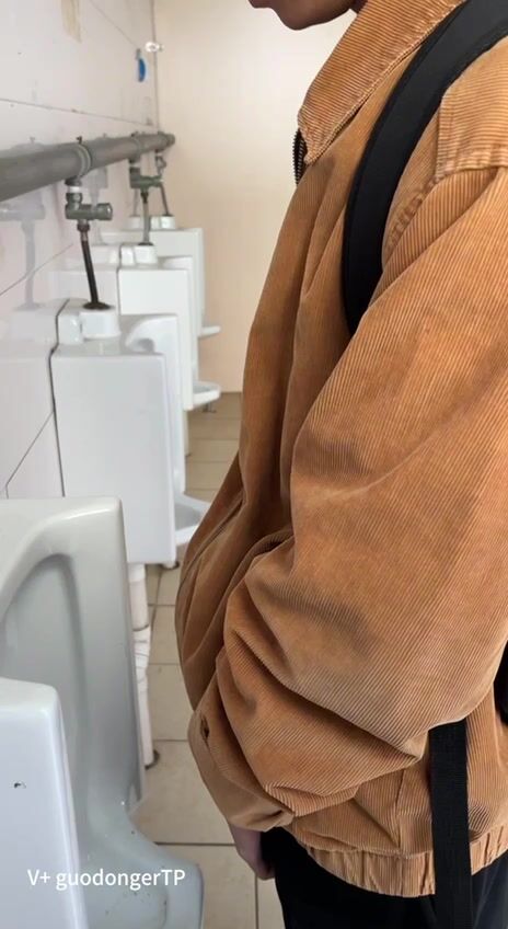 A male is pissing in the toilet. 23
