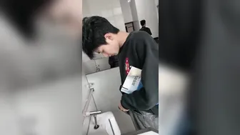 A male student is pissing in the toilet. 11