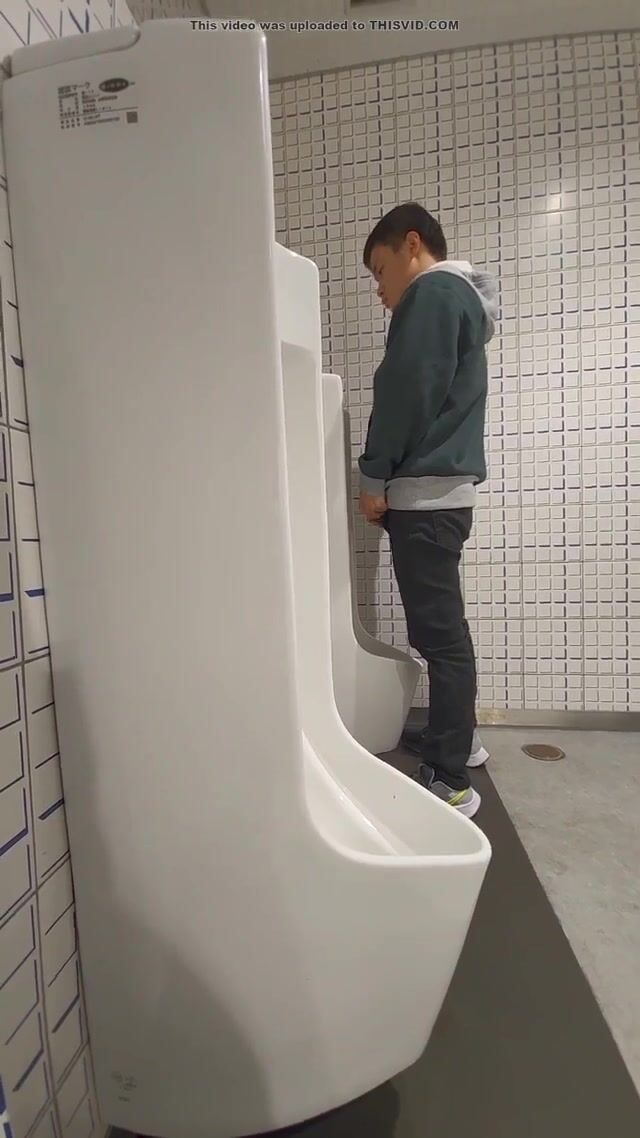 A male is pissing in the toilet. 24