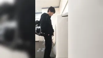 A male student is pissing in the toilet. 12